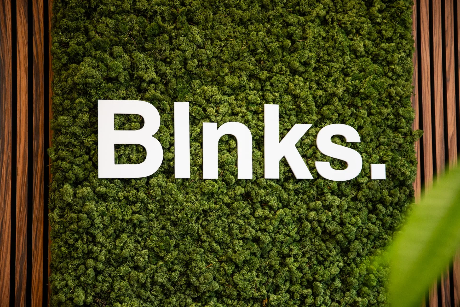 Blnks-logo op de groene moswand